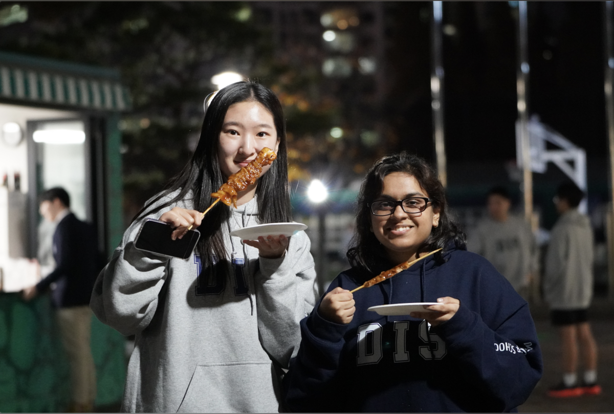 Juniors Niha Banerjee and Vivian Lee devour grilled chicken skewers to warm themselves up on a chilly evening. After finishing one, the rich flavor of the skewers leaves them craving more.